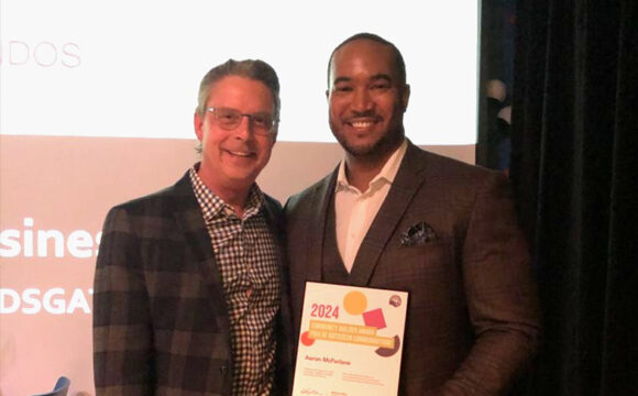 Aaron McFarlane and Derick Fage pose with a United Way East Ontario Community Builder Award